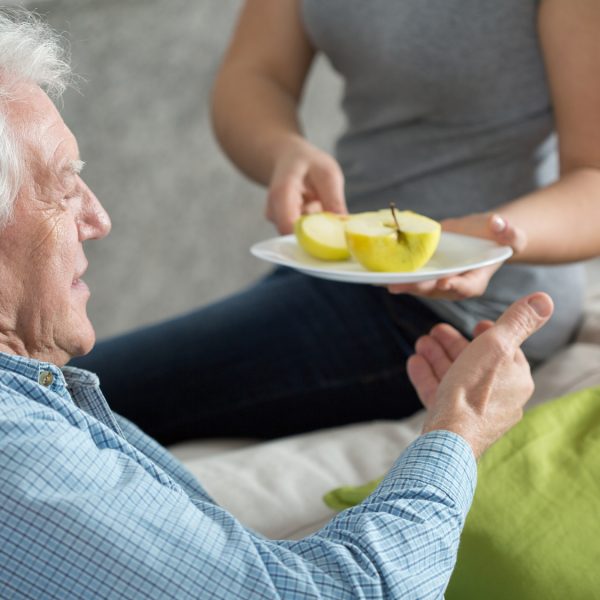 Elderly man eating fruit for dessert